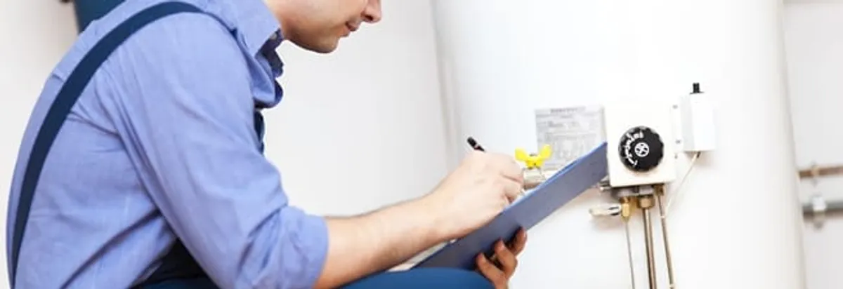 Water heater repair technician inspecting the unit and recording service notes in San Antonio, TX
